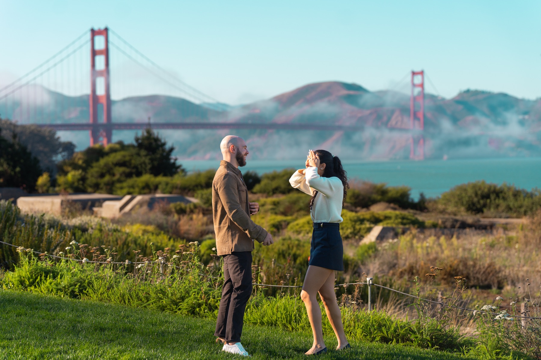 Alex and Abby walking together beneath the Golden Gate Bridge