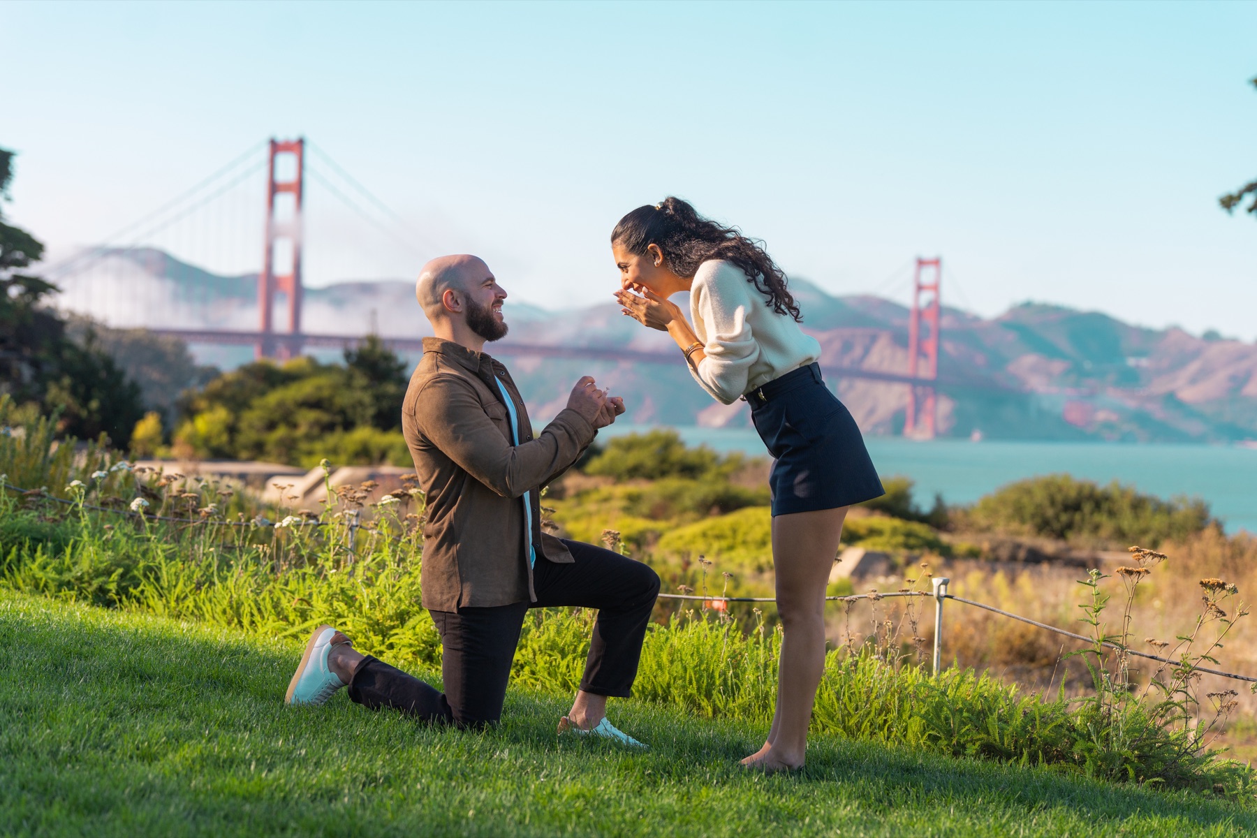 Alex proposing to Abby with the Golden Gate Bridge behind them