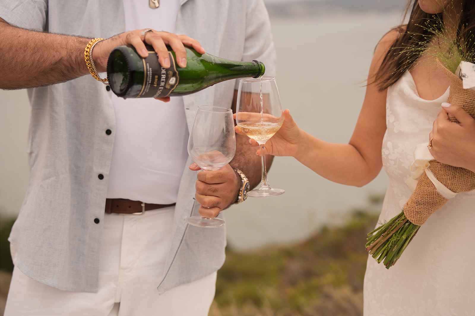 Couple toasting with champagne after their Golden Gate Bridge proposal