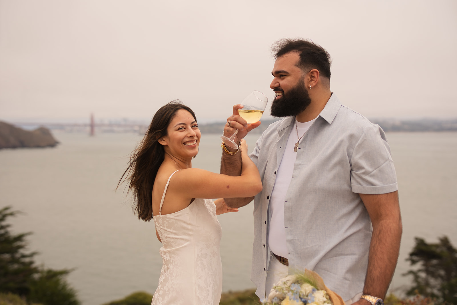 Couple celebrating together with the Golden Gate Bridge behind them