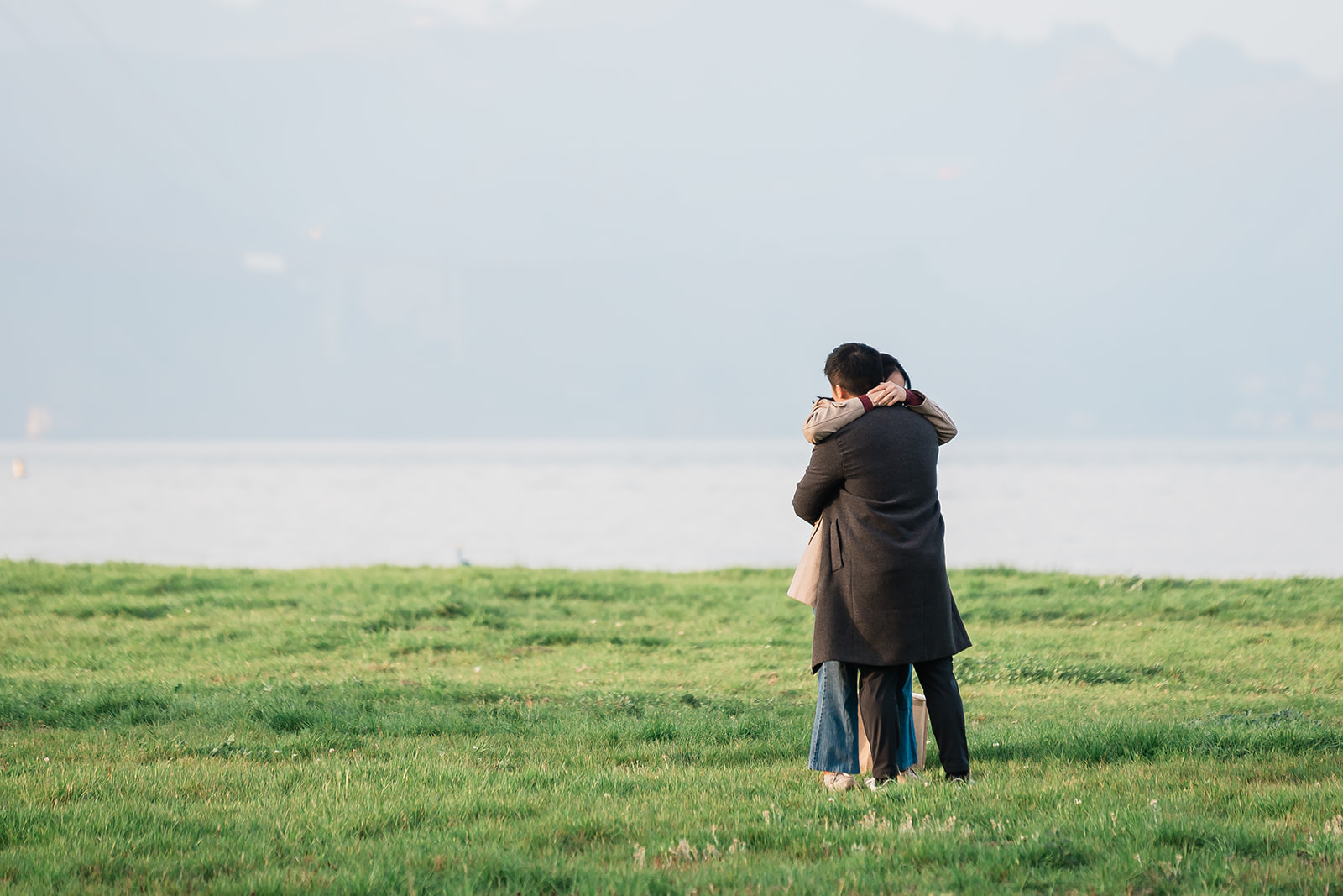 A couple during their Chrissy Field surprise proposal near the Golden Gate Bridge